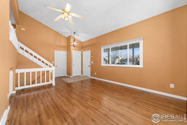 entrance foyer featuring visible vents, ceiling fan, baseboards, stairs, and wood finished floors