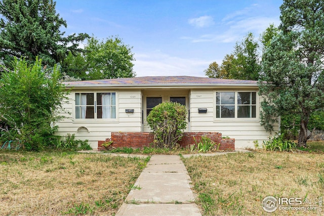 single story home with a front lawn