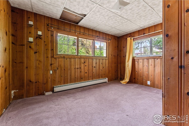 unfurnished room featuring a wealth of natural light, a baseboard radiator, and carpet flooring