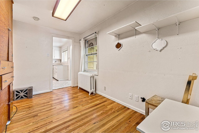 interior space with radiator, light wood-type flooring, and baseboards