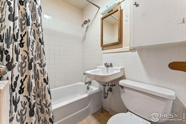 full bathroom with tile patterned flooring, toilet, radiator heating unit, shower / bath combo, and tile walls