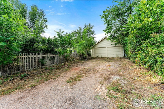 view of yard with an outdoor structure, fence, and an outbuilding