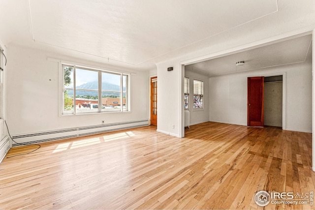 empty room featuring radiator, baseboard heating, and hardwood / wood-style flooring