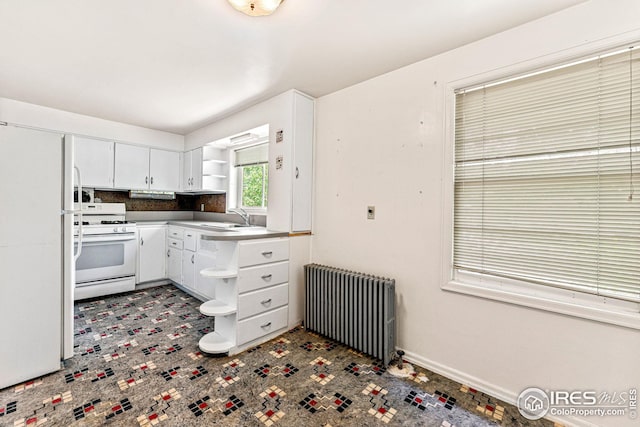 kitchen with white appliances, radiator, open shelves, a sink, and white cabinets