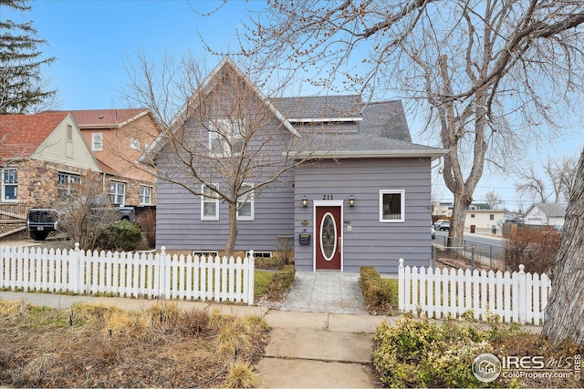 bungalow with a fenced front yard and roof with shingles