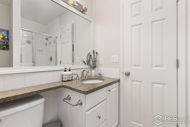 bathroom with vanity, a shower stall, and toilet