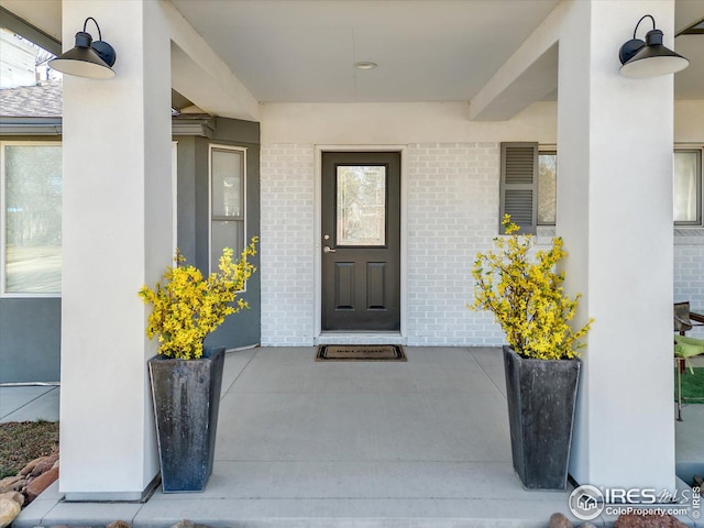 doorway to property featuring brick siding