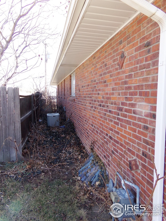 view of home's exterior featuring fence and brick siding