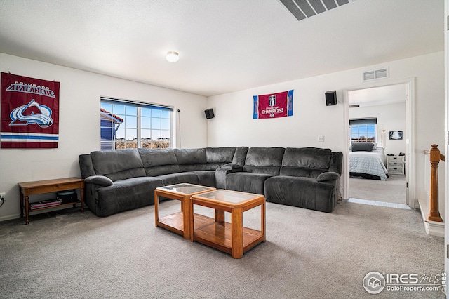 living room featuring carpet flooring, visible vents, and a wealth of natural light