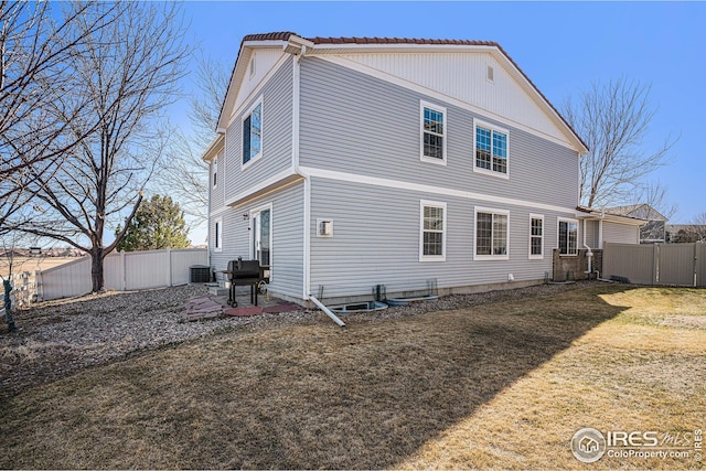 back of house with a yard and a fenced backyard