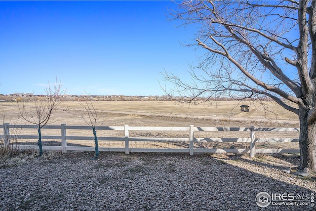 view of yard with a rural view and fence