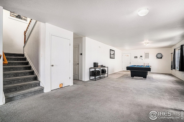 game room with pool table, carpet flooring, and a textured ceiling