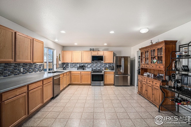 kitchen with a sink, tasteful backsplash, appliances with stainless steel finishes, and recessed lighting