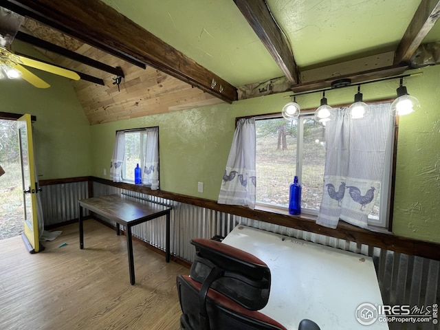 recreation room with a ceiling fan, wood finished floors, a wainscoted wall, lofted ceiling with beams, and a textured wall