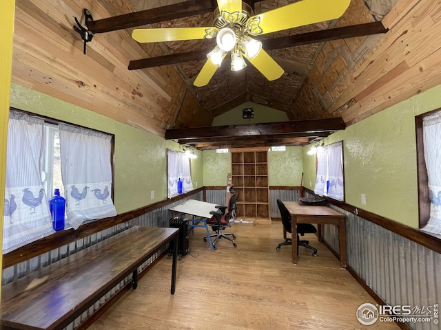 home office featuring wainscoting, vaulted ceiling with beams, wood finished floors, and a textured wall