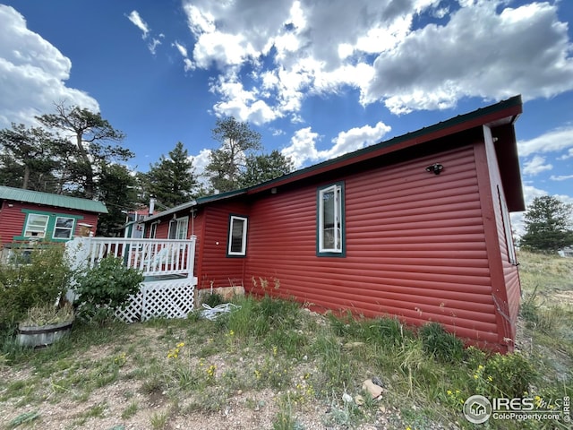 view of side of property featuring faux log siding and a wooden deck