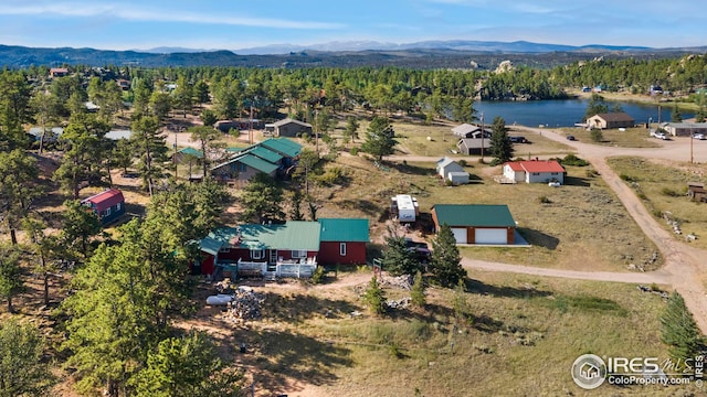 drone / aerial view featuring a forest view and a water and mountain view