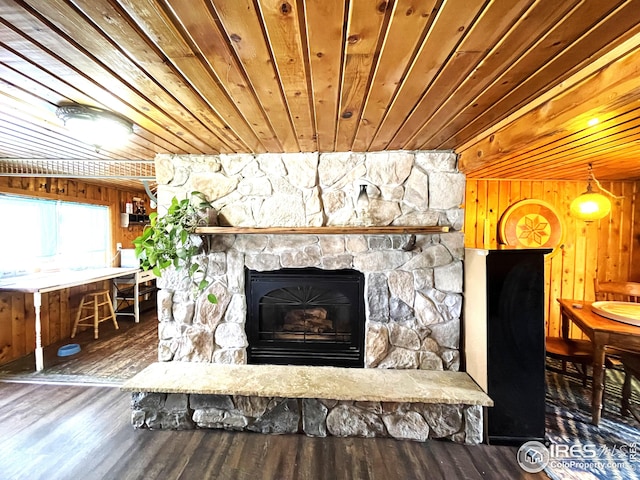room details featuring wooden ceiling, wood finished floors, wood walls, and a fireplace