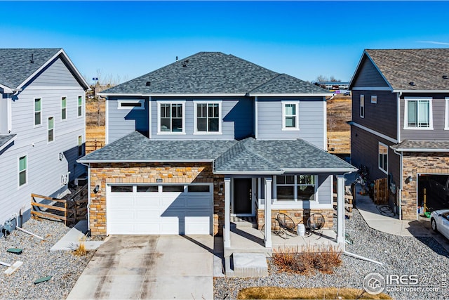 traditional-style home featuring stone siding, roof with shingles, concrete driveway, and fence