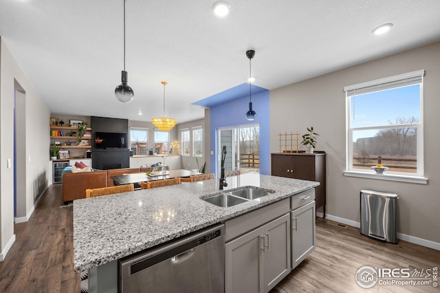 kitchen with dishwasher, wood finished floors, a wealth of natural light, and a sink