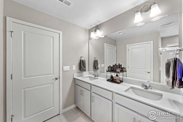 full bathroom with a sink, visible vents, double vanity, and tile patterned flooring