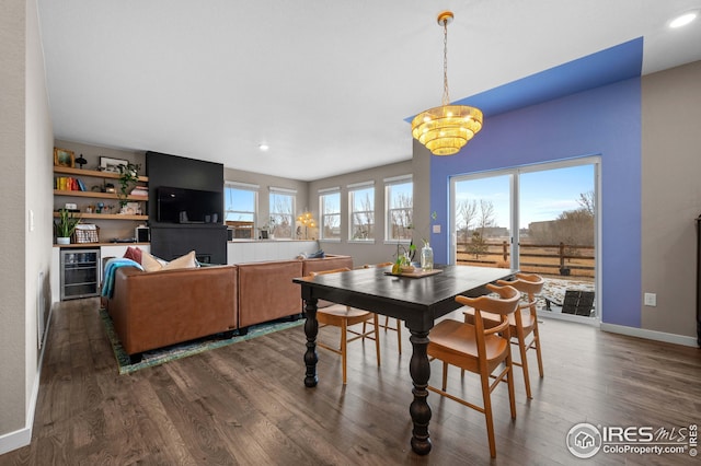 dining space with dark wood finished floors, wine cooler, plenty of natural light, and baseboards