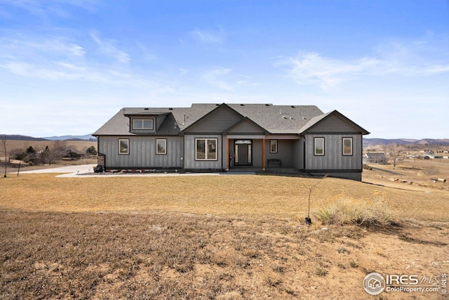 modern farmhouse featuring a mountain view, board and batten siding, and a shingled roof