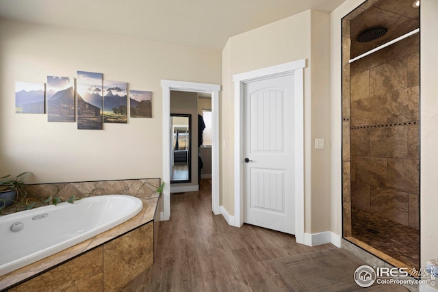 full bath with baseboards, tiled shower, a garden tub, and wood finished floors