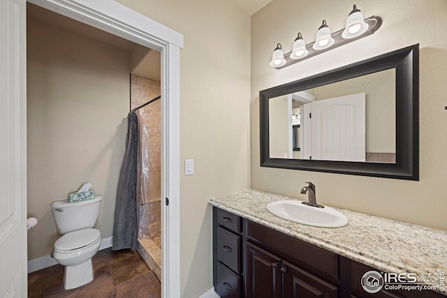 full bath featuring vanity, a shower stall, toilet, and baseboards