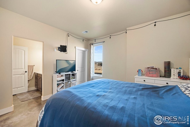 bedroom with visible vents, baseboards, concrete floors, and ensuite bath