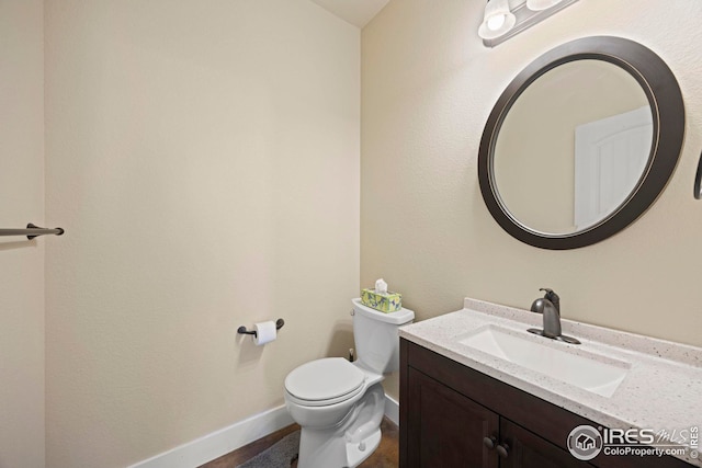 bathroom featuring vanity, toilet, and baseboards