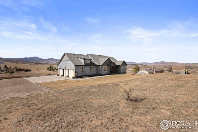 view of front of property with a mountain view, a garage, and concrete driveway