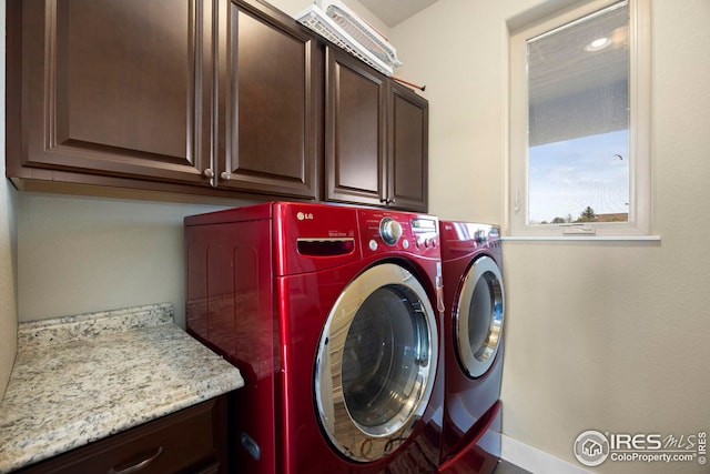 washroom featuring washer and dryer and cabinet space