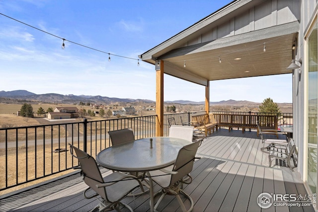 wooden deck featuring outdoor dining space and a mountain view