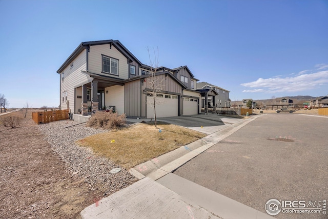 view of front of home with an attached garage, a porch, driveway, and fence