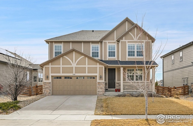 tudor-style house featuring stucco siding, stone siding, covered porch, and concrete driveway