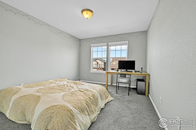 bedroom with baseboards, a textured wall, and carpet floors