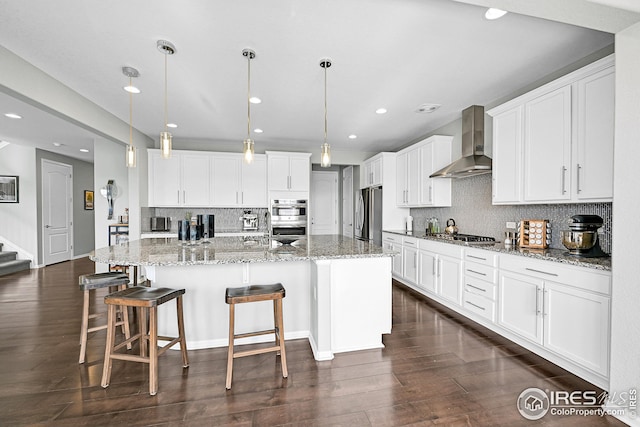 kitchen featuring white cabinetry, wall chimney range hood, dark wood-style floors, and stainless steel appliances