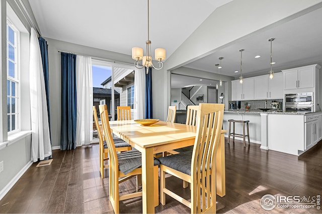 dining space featuring visible vents, an inviting chandelier, dark wood-style floors, and vaulted ceiling