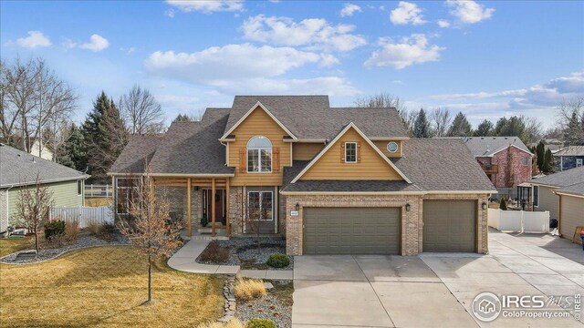 view of front of house featuring a front yard, fence, driveway, a shingled roof, and brick siding