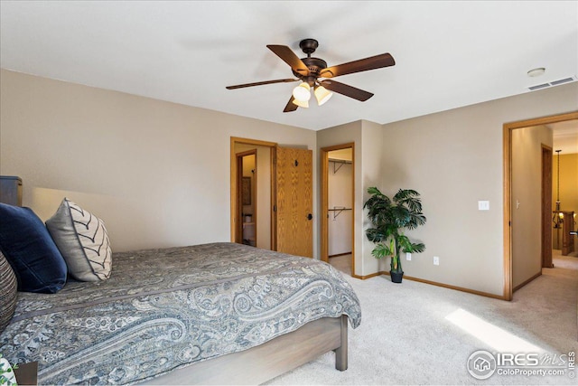 carpeted bedroom featuring visible vents, baseboards, a ceiling fan, and a spacious closet