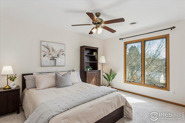 bedroom with visible vents, baseboards, light colored carpet, and ceiling fan