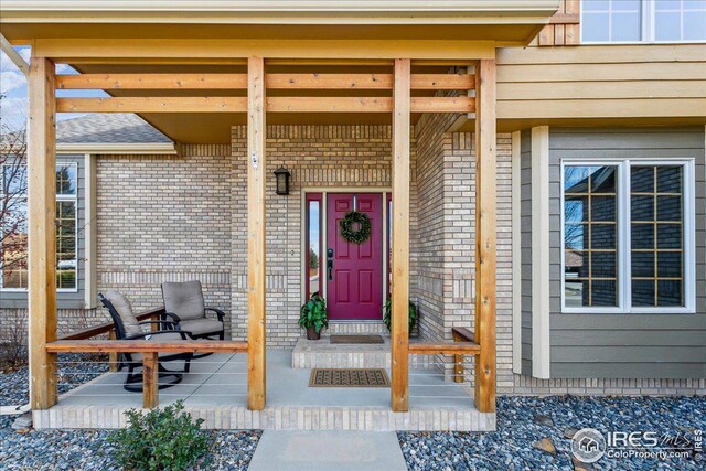 entrance to property with brick siding and covered porch