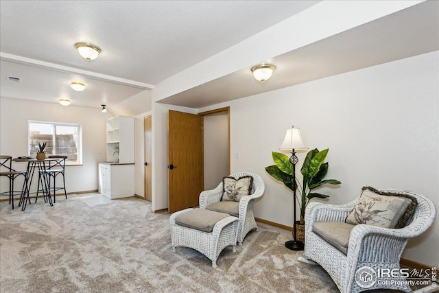 living area with visible vents, baseboards, and carpet