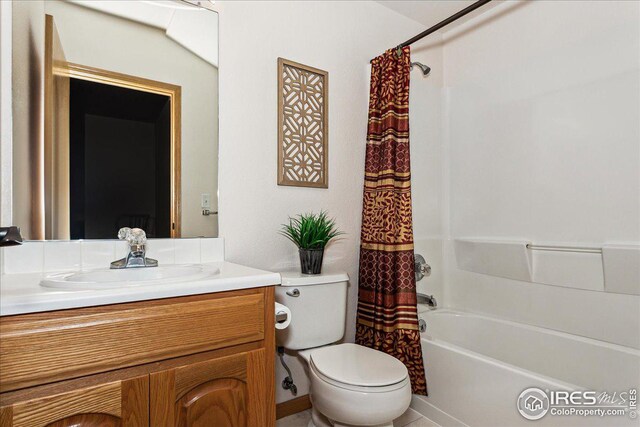 full bathroom featuring toilet, shower / bath combo, and vanity