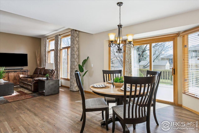 dining room featuring a healthy amount of sunlight, an inviting chandelier, and wood finished floors