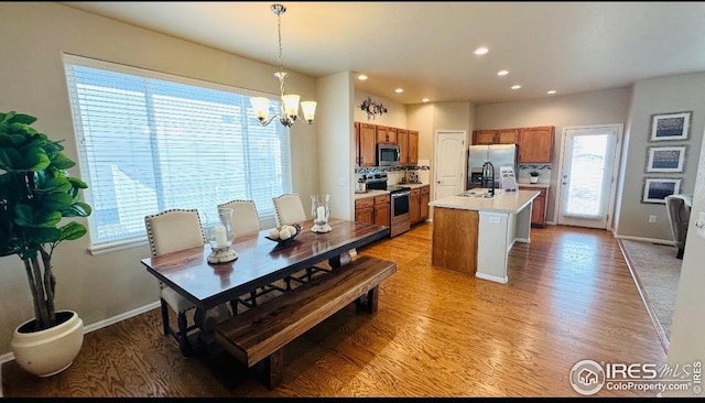 dining room featuring a notable chandelier, light wood-style floors, recessed lighting, and baseboards