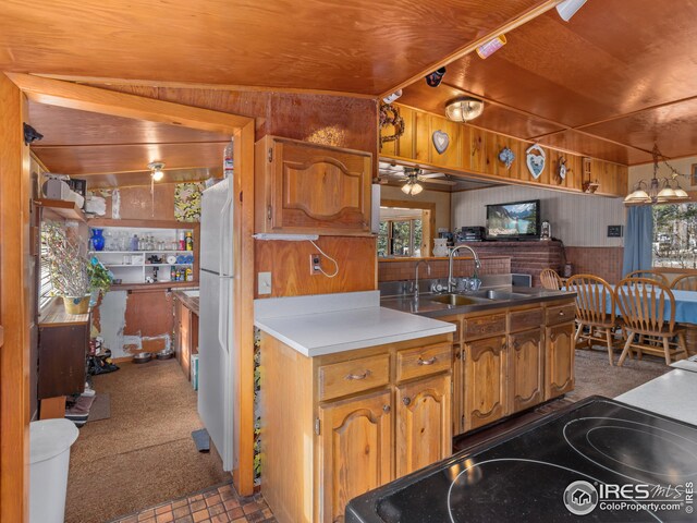 kitchen with a sink, a peninsula, wood walls, and electric stove