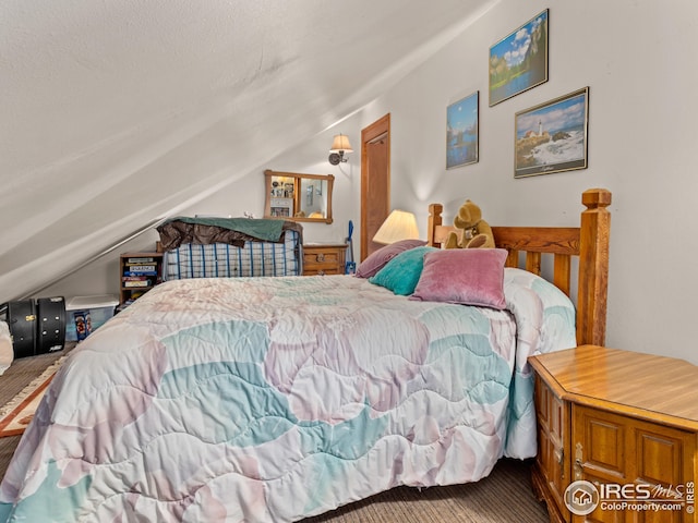 bedroom with a textured ceiling and vaulted ceiling