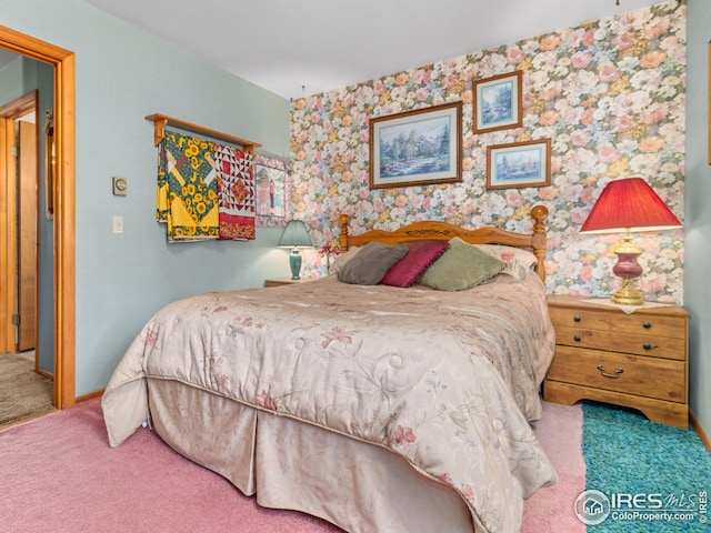 carpeted bedroom featuring wallpapered walls and baseboards